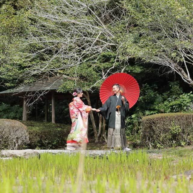 レンタル＆フォトスタジオの光翔　和服姿の傘を持ったご新郎様とご新婦様の写真