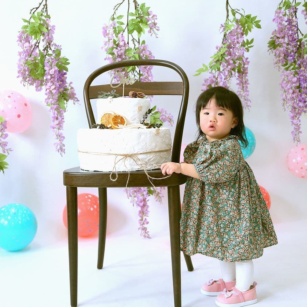 レンタル＆フォトスタジオの光翔　鉾田市　babyのギャラリーケーキの載った椅子につかまり立ちしている女の子