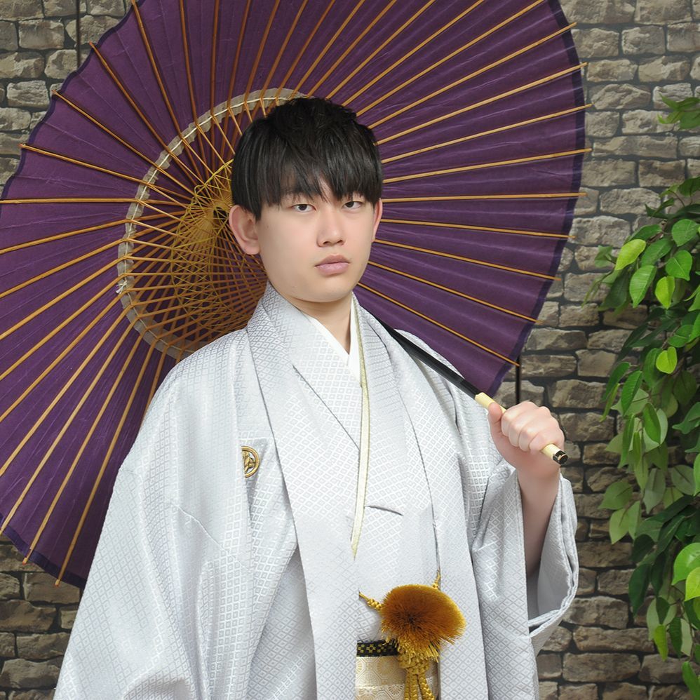 レンタル＆フォトスタジオの光翔　茨城県鉾田市　成人式の紋服を着て傘をさして立っている男性の写真