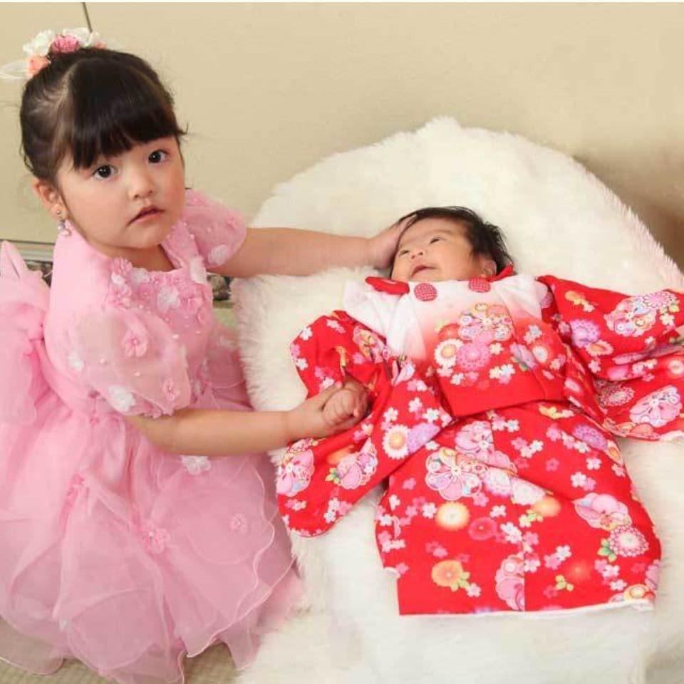 レンタル＆フォトスタジオの光翔　お宮参りの赤ちゃんとピンクのドレスを着たお姉ちゃんの写真