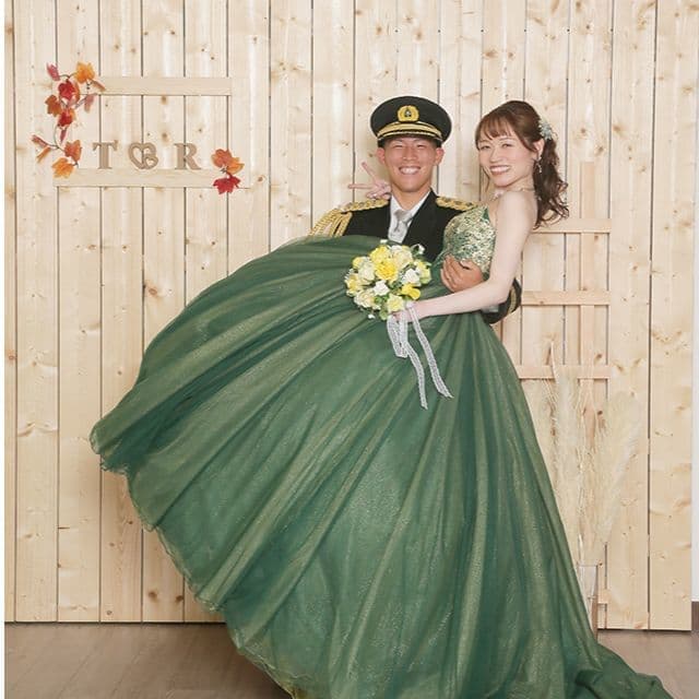 レンタル＆フォトスタジオの光翔　緑のドレスを着たご新婦様をご新郎様が抱っこしている写真