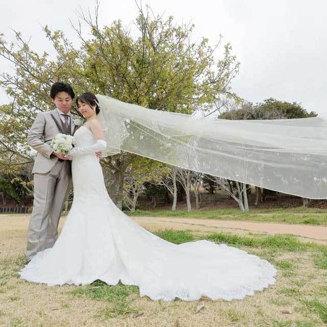 レンタル＆フォトスタジオの光翔　ベールが風になびいているご新郎様ご新婦様の写真